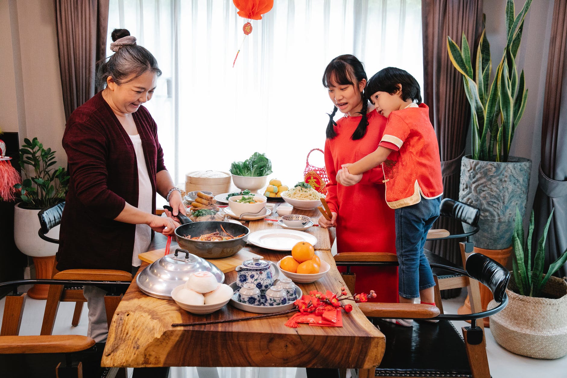 positive asian woman cooking chinese food for festive occasion