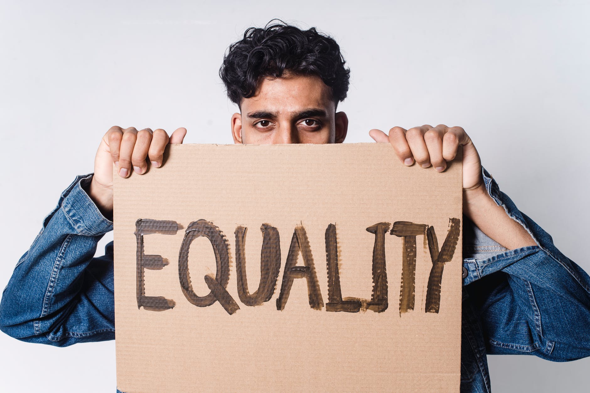 man holding cardboard with equality text