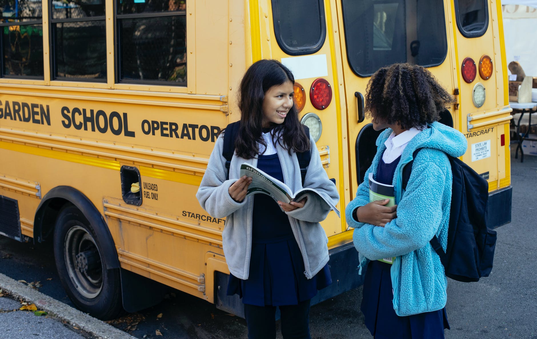 cute diverse children near school bus