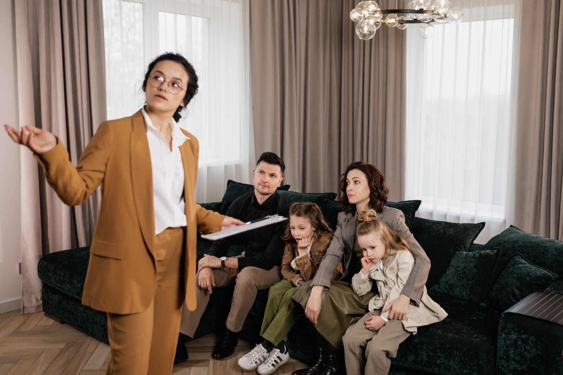 woman in brown blazer showing house to a family