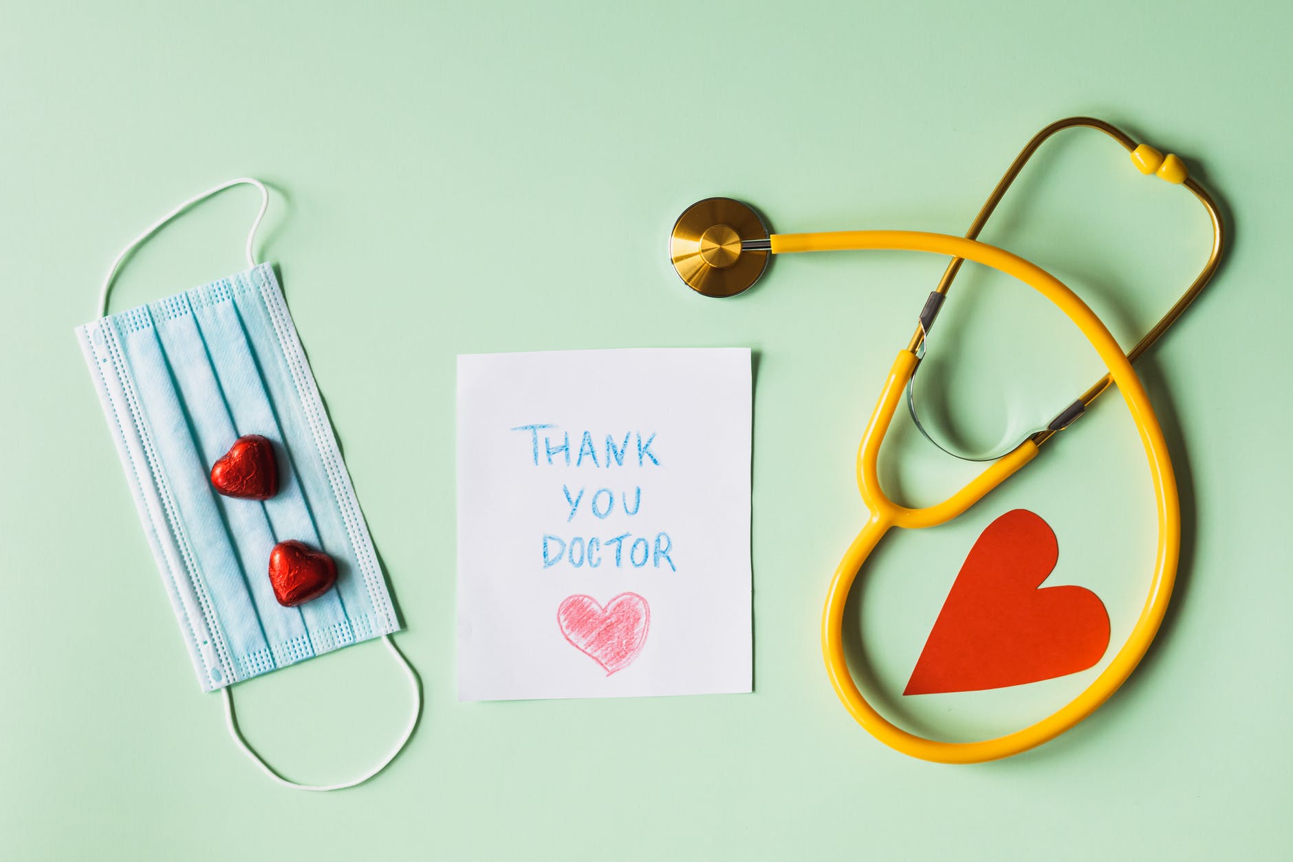 thank you doctor note next to a face mask and a stethoscope