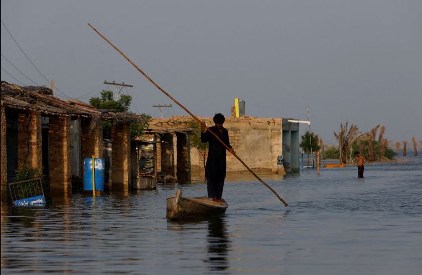 A man rows his boat as he passes through flooded market, following rains and floods during the monsoon season in Bajara village, at the banks of Manchar lake, in Sehwan, Pakistan September 6, 2022. REUTERS/Akhtar Soomro