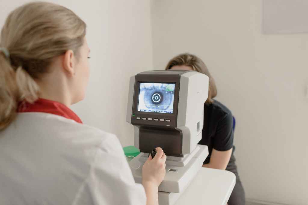 anonymous oculist examining vision of patient on eye screener