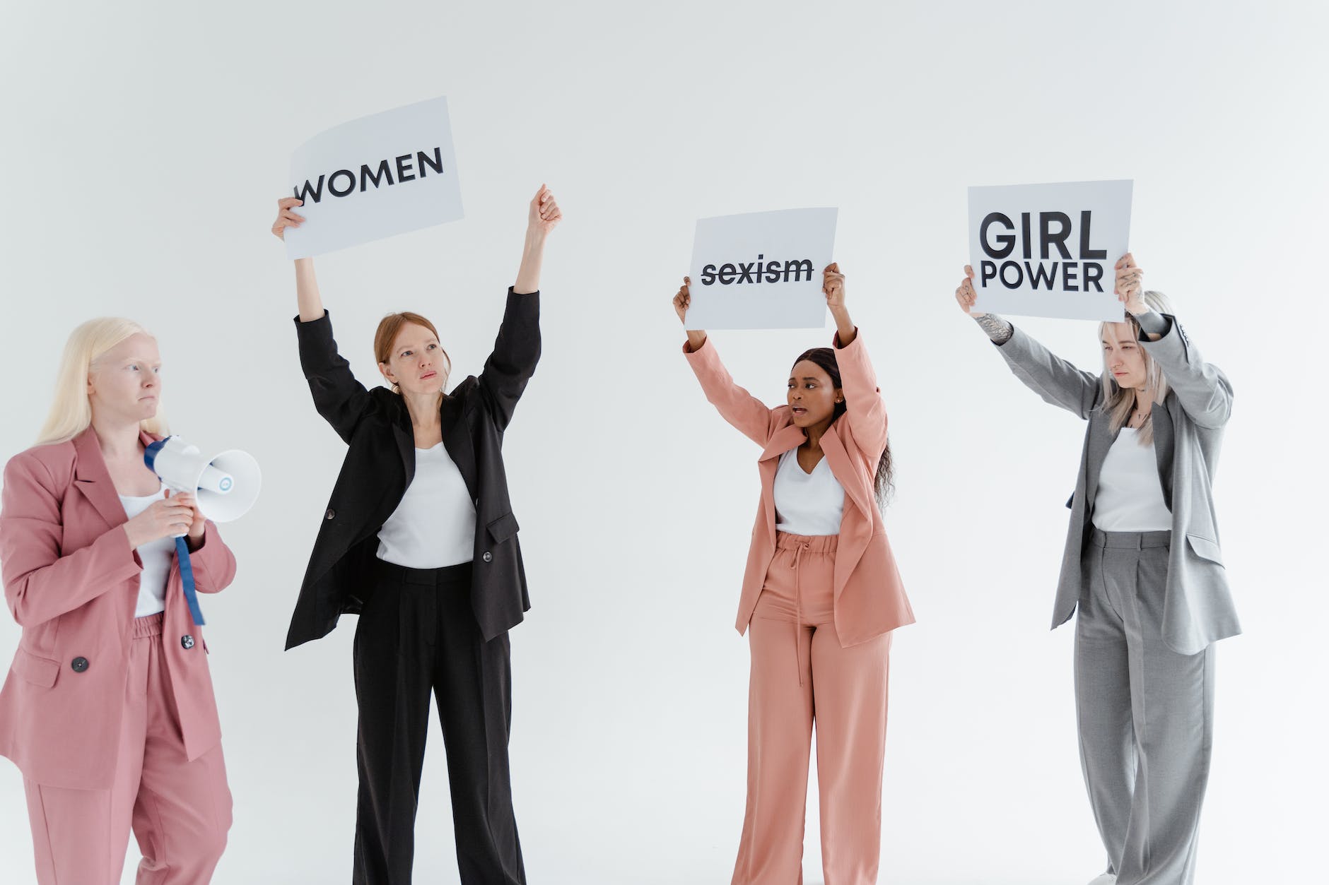 a group of women in formal wear holding banners