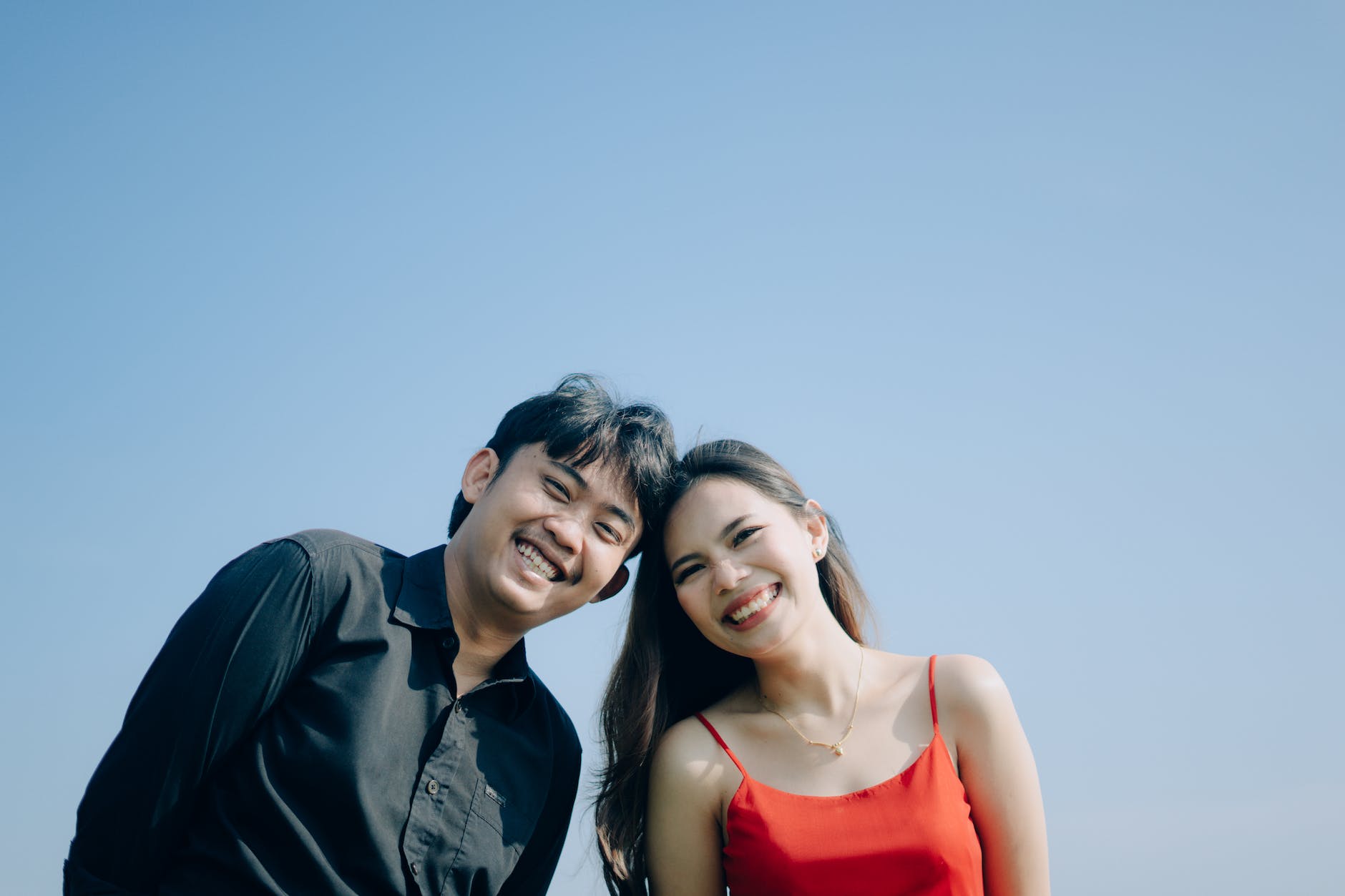 portrait of smiling couple against blue sky