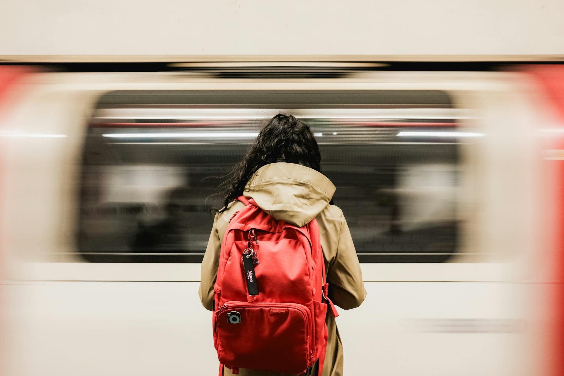 commuter with red backpack at london underground station