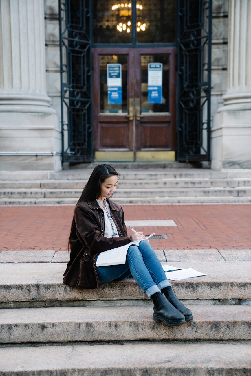 girl sitting on city stairs studying