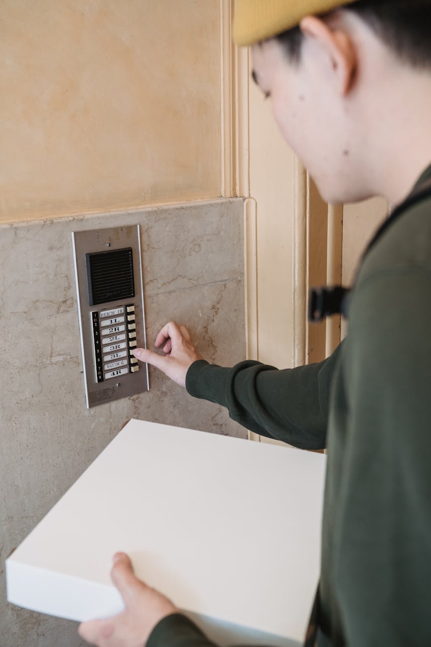 a courier pressing an intercom doorbell