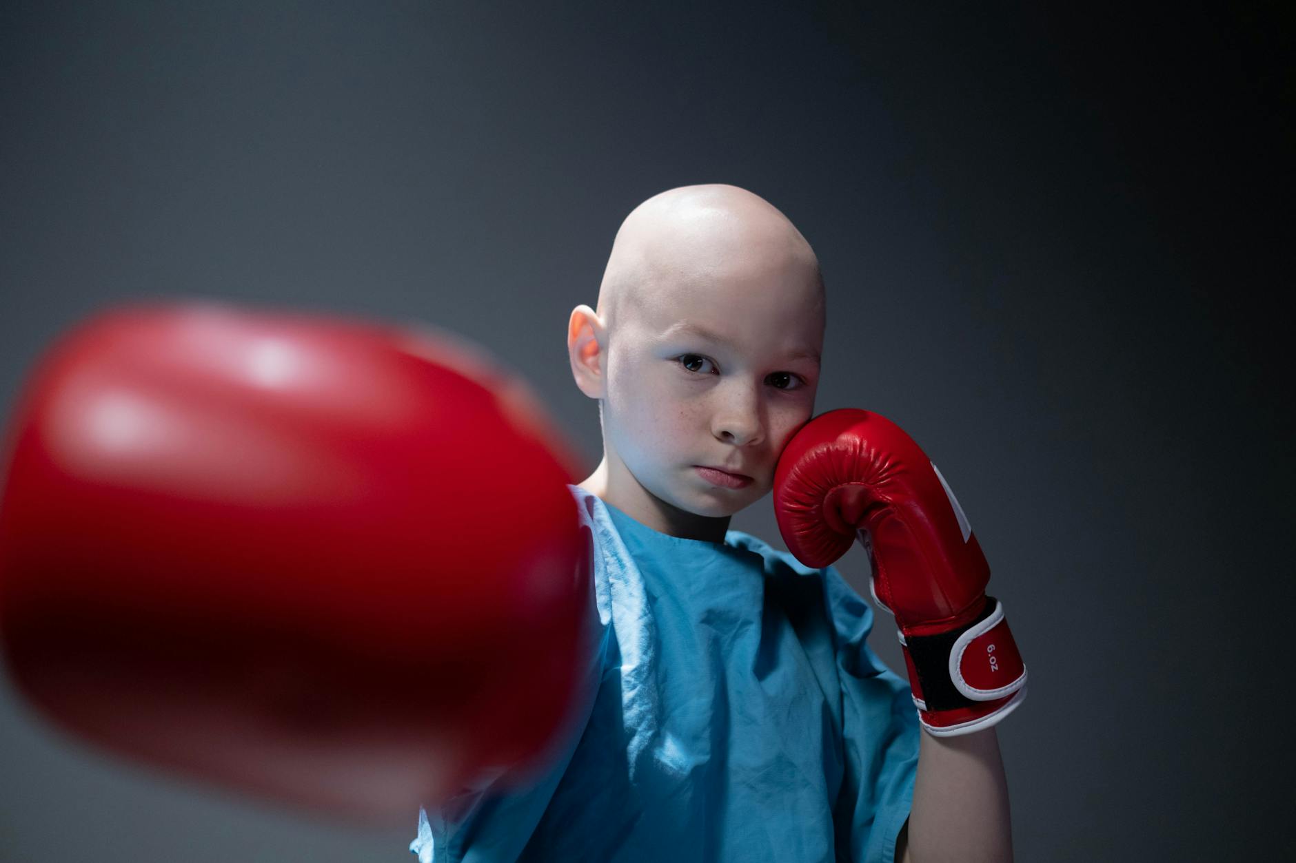 child punching while wearing boxing gloves