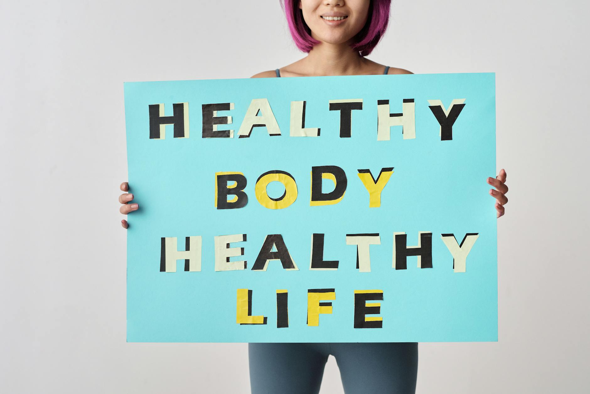 person holding a blue poster with message