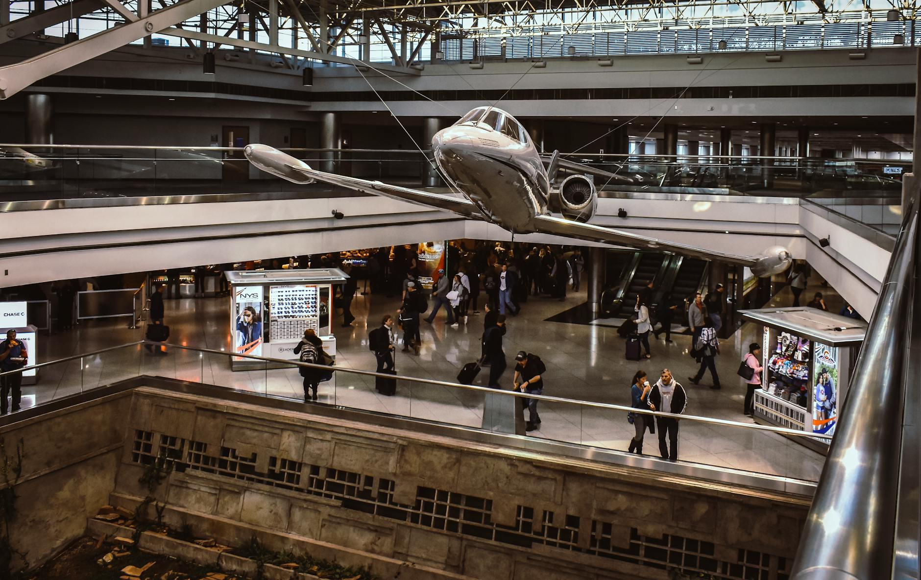 silver plane on display in museum with people