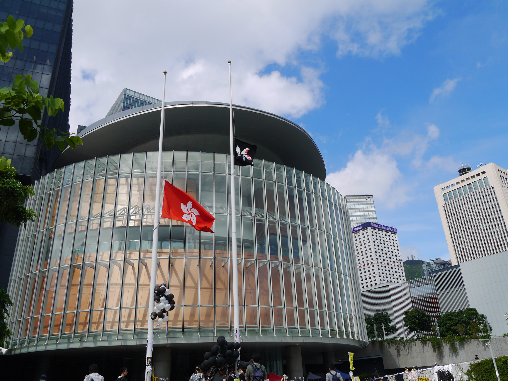 flag poles beside a white building