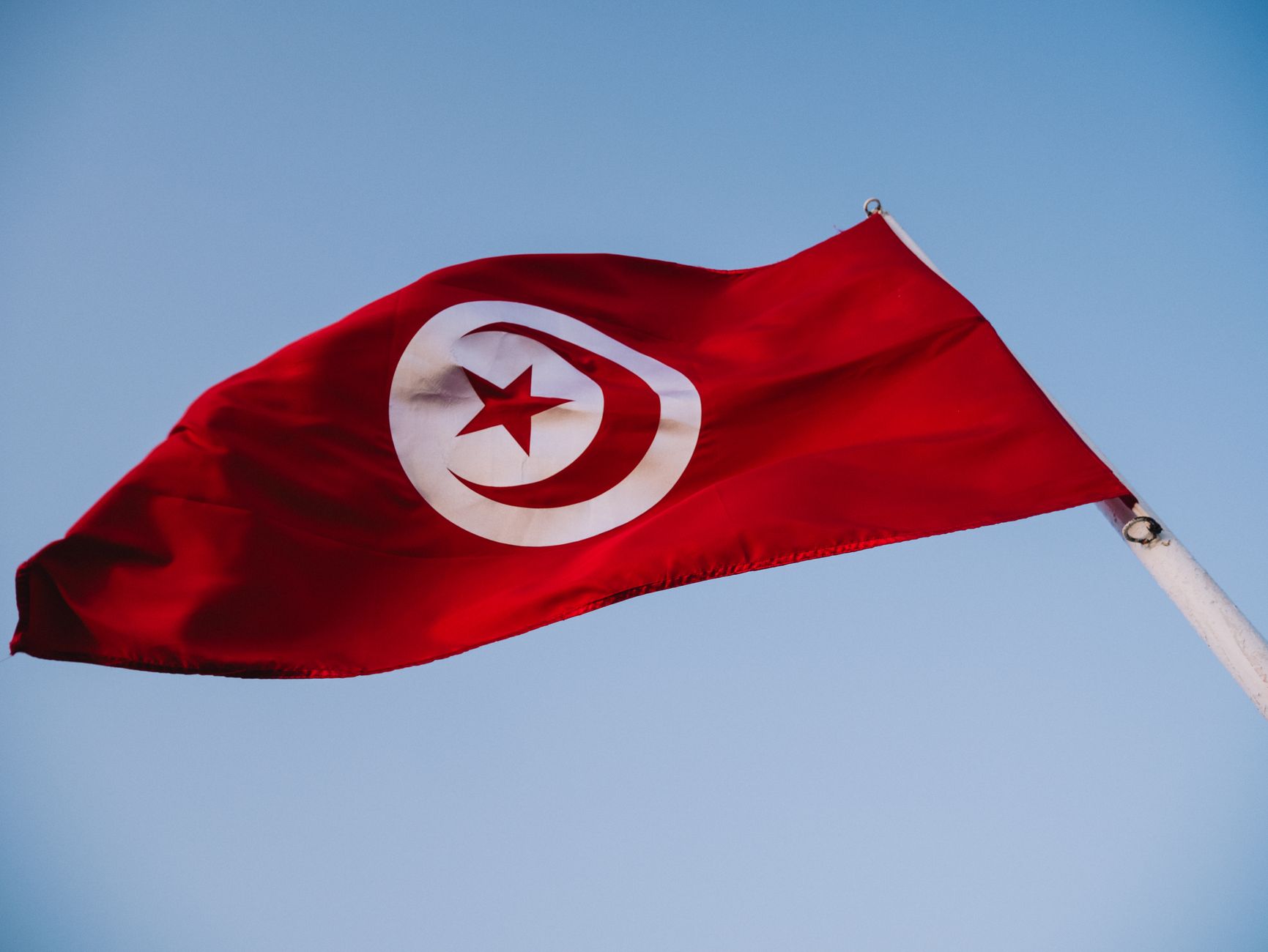 tunisian flag fluttering against blue sky