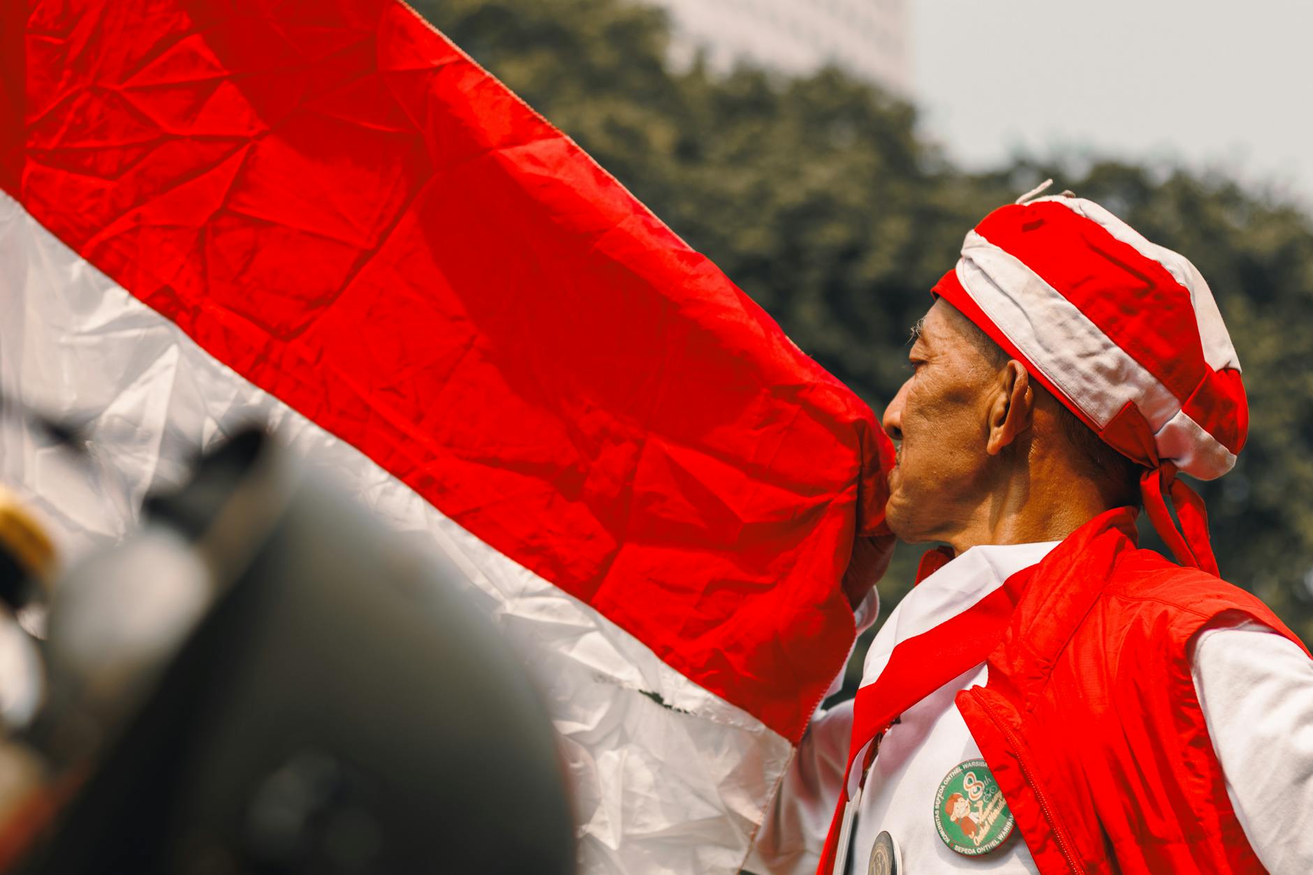patriot kissing indonesian flag outdoors