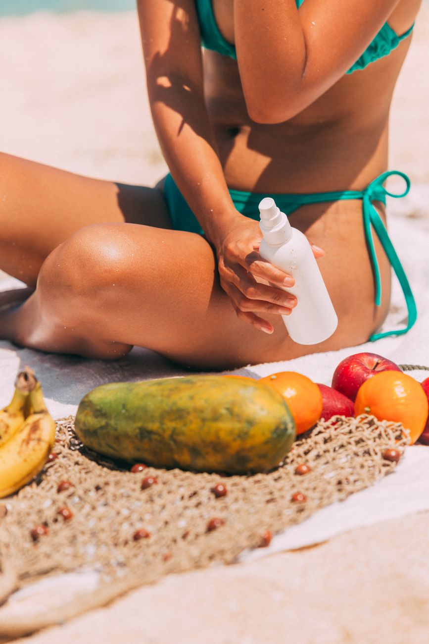 a woman in green bikini holding white plastic bottle
