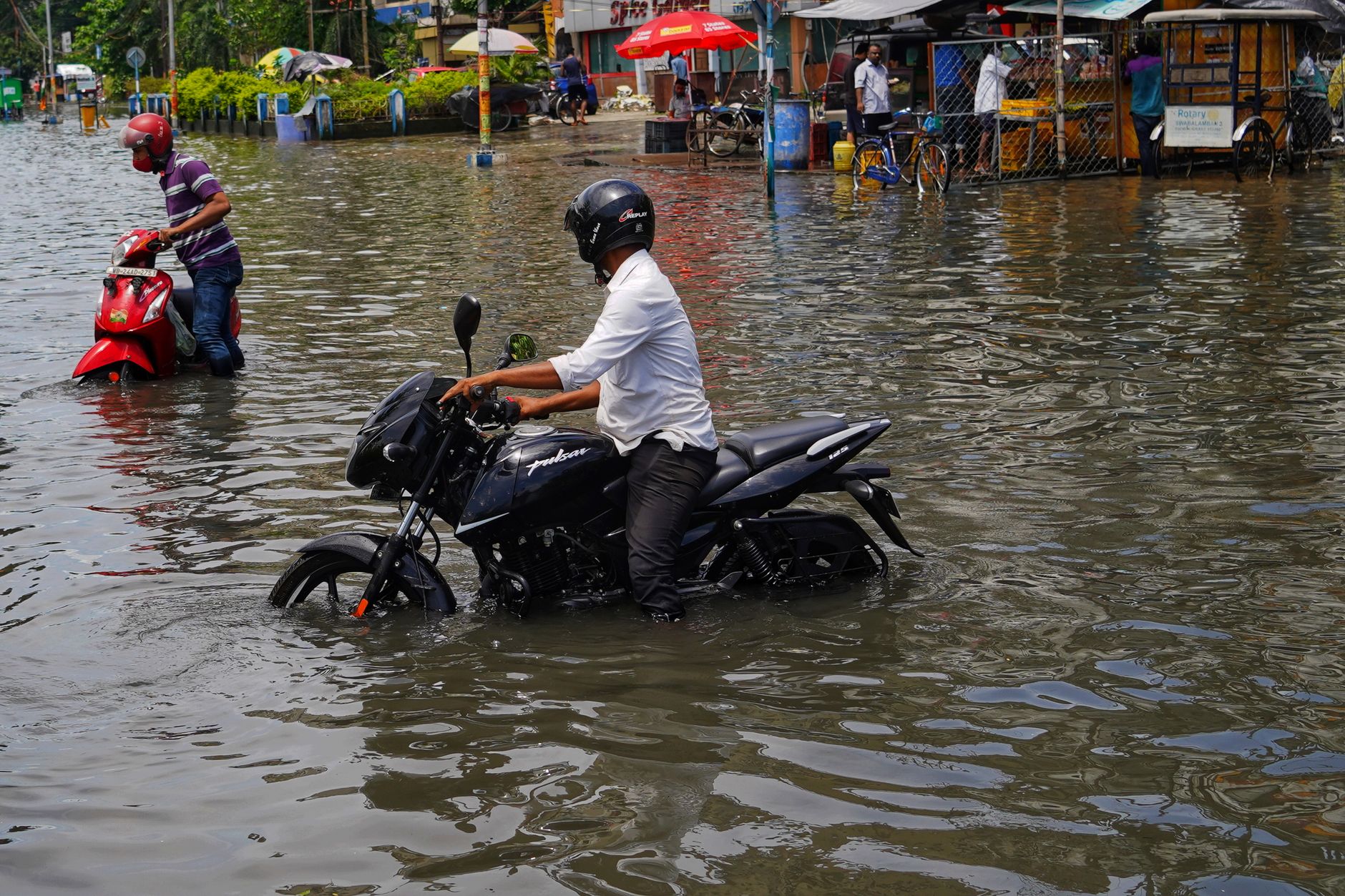 men riding motorcycles on a flooded street