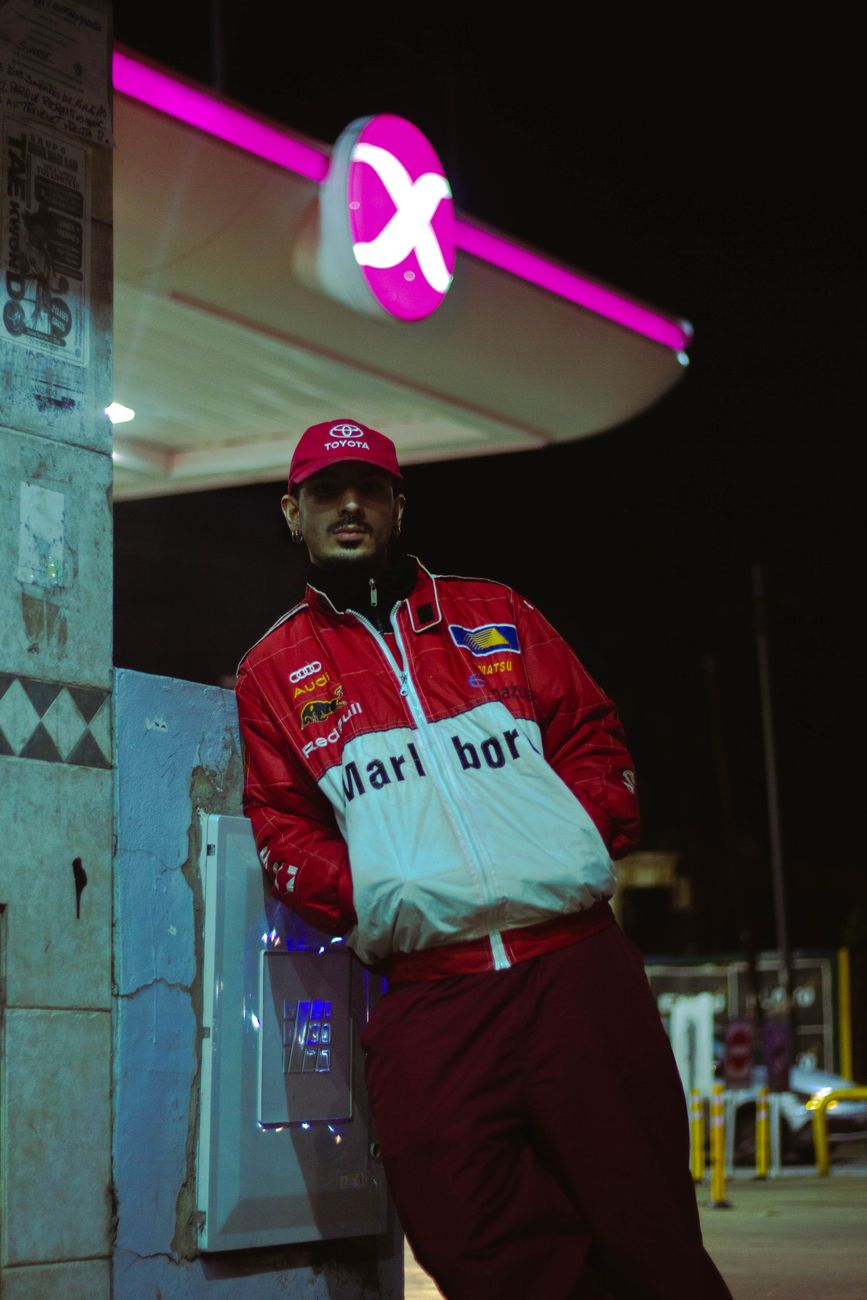 racer in red jacket at nighttime gas station